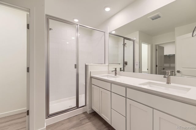 bathroom featuring vanity, an enclosed shower, and wood-type flooring