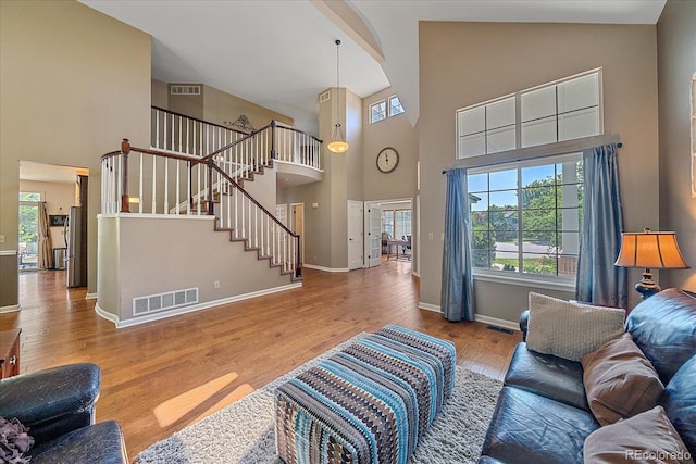 10421 Kennemere Ln, Parker, CO 80134 - living area with high vaulted ceiling, stairs, plenty of natural light, and wood finished floors