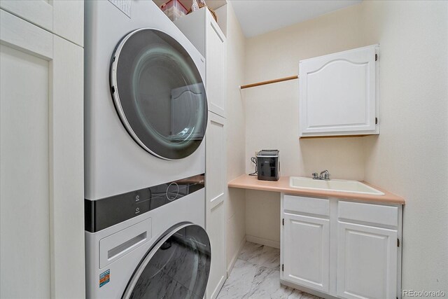 10421 Kennemere Ln, Parker, CO 80134 - laundry room featuring stacked washing machine and dryer, cabinet space, and light marble finish floors