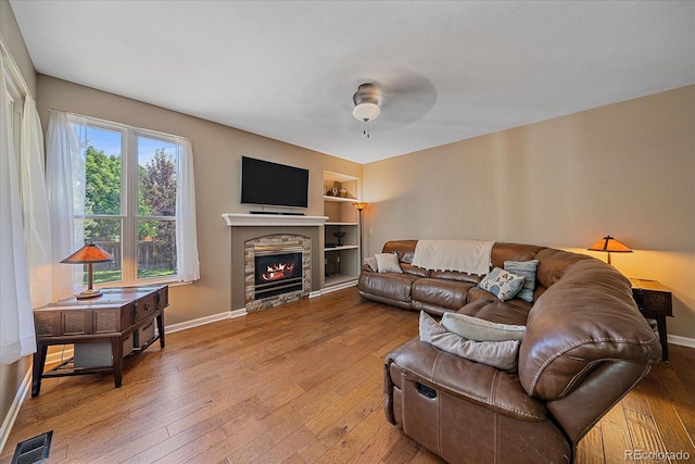 10421 Kennemere Ln, Parker, CO 80134 - living area featuring hardwood / wood-style floors, built in shelves, a fireplace, and ceiling fan