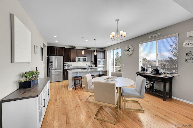 dining space featuring light hardwood / wood-style floors and a chandelier