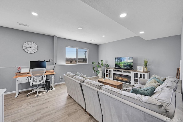 living room with light hardwood / wood-style flooring and a textured ceiling