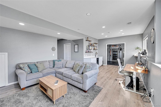 living room featuring light hardwood / wood-style flooring and wet bar