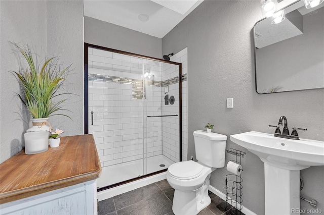 bathroom with tile patterned flooring, sink, an enclosed shower, and toilet