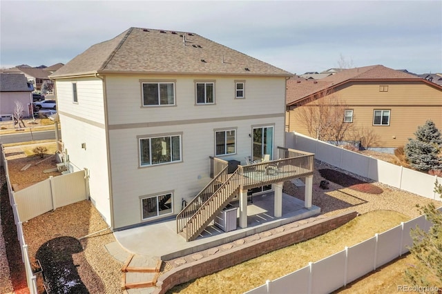 back of property featuring a deck and a patio