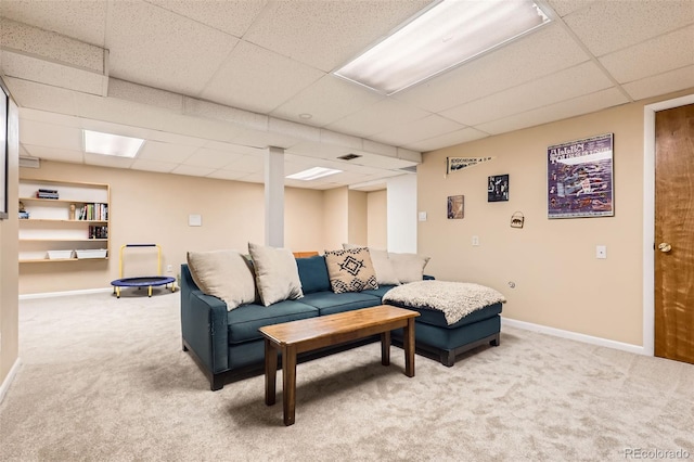 living room featuring baseboards, a paneled ceiling, and light carpet