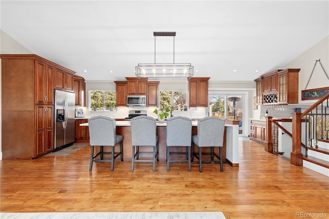 kitchen with light countertops, a breakfast bar area, light wood-style floors, and stainless steel appliances