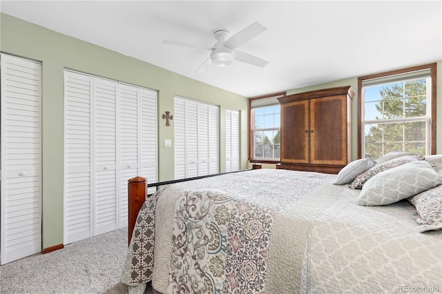 bedroom featuring multiple closets, carpet, and ceiling fan