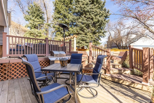 wooden terrace with outdoor dining area and grilling area