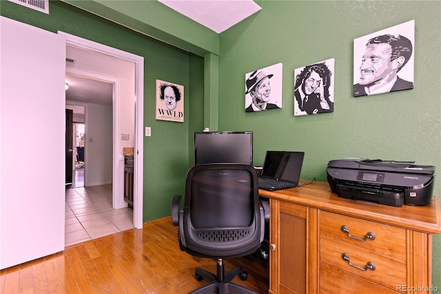 office area with light wood finished floors and visible vents