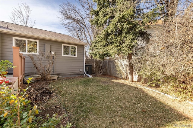 view of yard featuring central AC unit and fence