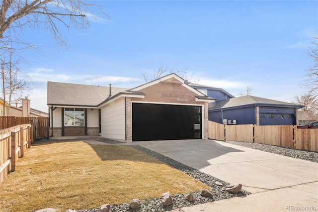 view of front of property with fence, concrete driveway, a front yard, a garage, and brick siding