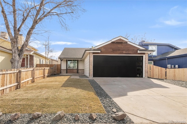 view of front of home featuring a front lawn, driveway, fence, an attached garage, and brick siding