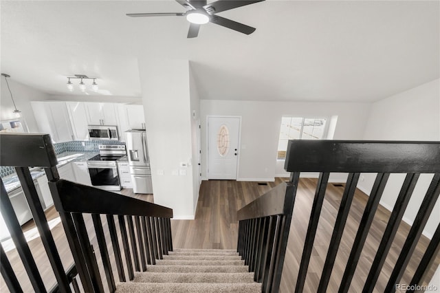 staircase featuring baseboards and wood finished floors