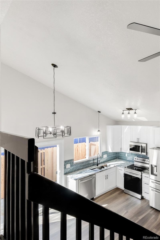 kitchen with a sink, tasteful backsplash, stainless steel appliances, light countertops, and lofted ceiling