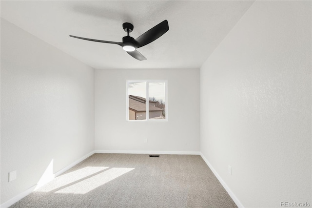 carpeted spare room with a ceiling fan, visible vents, and baseboards