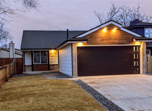 view of front of property featuring a front lawn, fence, a garage, and driveway