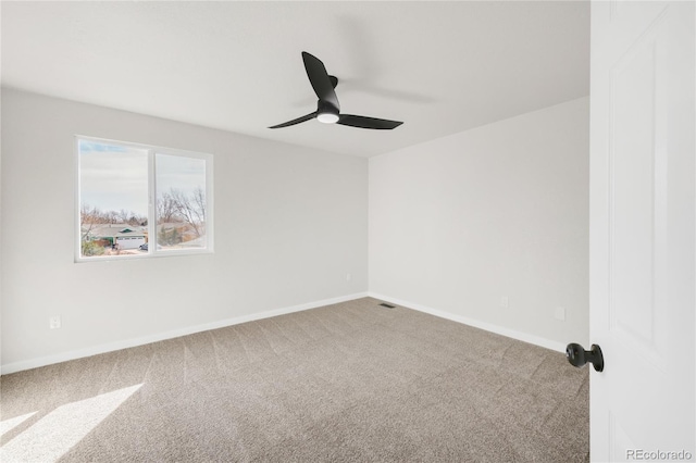 carpeted empty room with a ceiling fan and baseboards