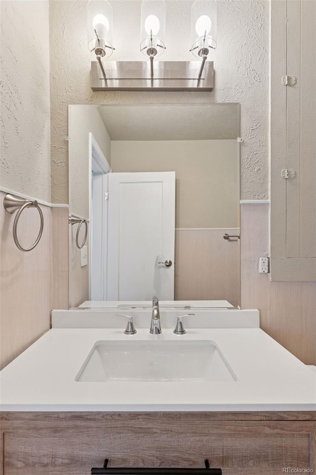 448 K Ave, Limon, CO 80828 - bathroom featuring a textured wall, a wainscoted wall, vanity, and wood walls