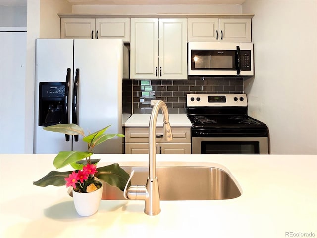 9650 Huron St Unit 3, Thornton, CO 80260 - kitchen featuring appliances with stainless steel finishes, light countertops, and decorative backsplash
