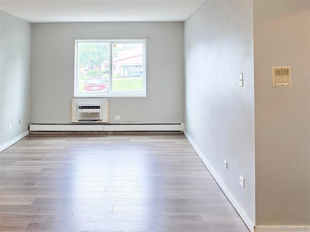 9650 Huron St Unit 3, Thornton, CO 80260 - unfurnished room featuring baseboard heating, wood finished floors, and a wall mounted AC