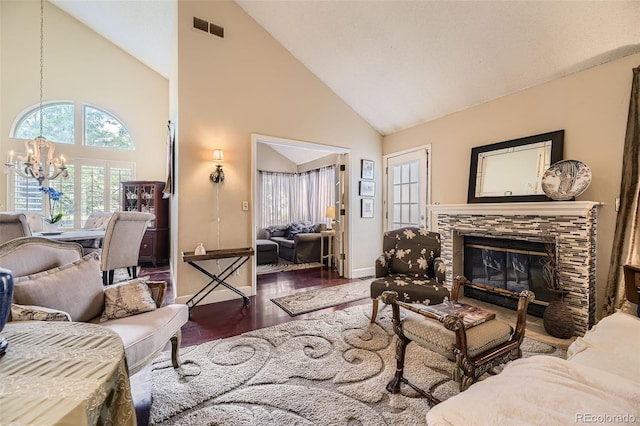 2238 S Nome Ct, Aurora, CO 80014 - living area featuring a chandelier, high vaulted ceiling, wood finished floors, and a stone fireplace