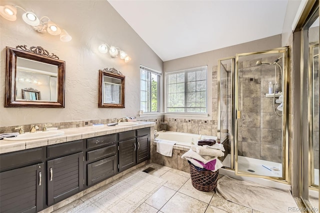 2238 S Nome Ct, Aurora, CO 80014 - bathroom with vaulted ceiling, a bath, a stall shower, double vanity, and tile patterned floors