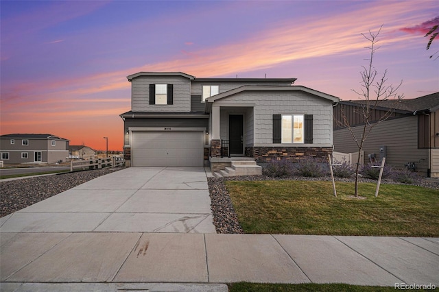 view of front facade featuring stone siding, an attached garage, a front lawn, and concrete driveway