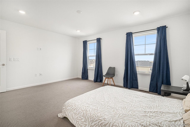 bedroom featuring light carpet and multiple windows