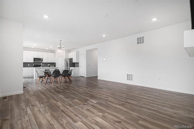living room with visible vents, an inviting chandelier, and recessed lighting