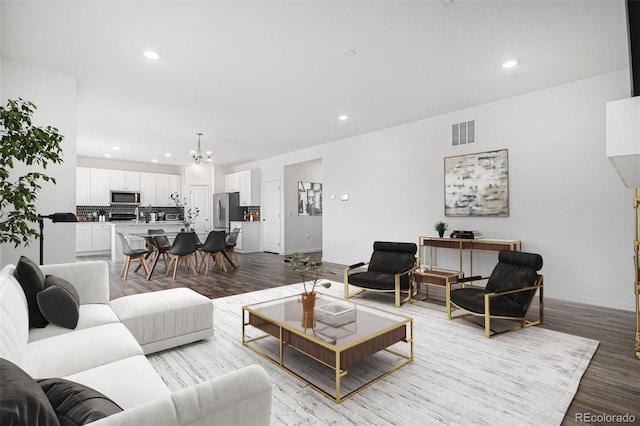 living area featuring recessed lighting, visible vents, light wood-style floors, baseboards, and a chandelier