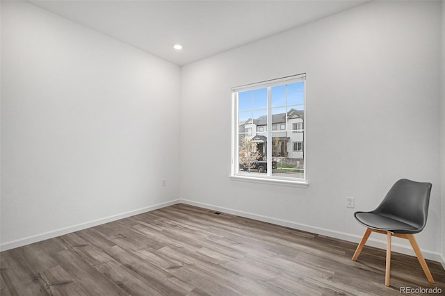 unfurnished room featuring recessed lighting, wood finished floors, and baseboards