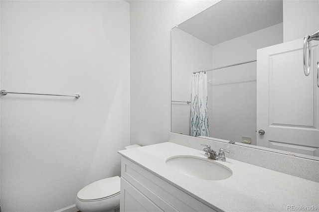 bathroom with toilet, vanity, a shower with shower curtain, and baseboards