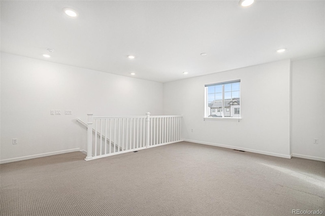 carpeted spare room featuring baseboards and recessed lighting
