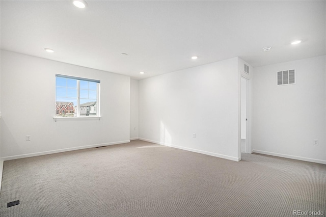 carpeted empty room featuring baseboards, visible vents, and recessed lighting