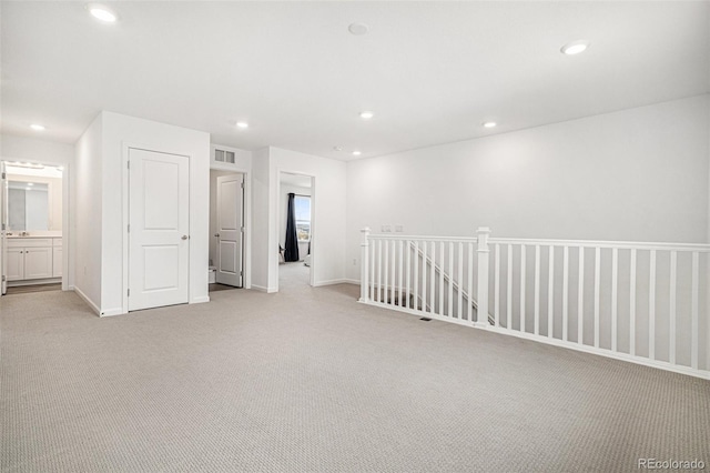 unfurnished room with baseboards, light carpet, visible vents, and recessed lighting