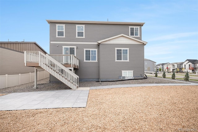 back of property with a wooden deck, stairway, and fence