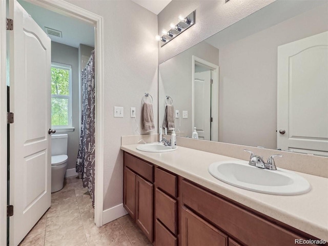 bathroom featuring toilet, vanity, and tile patterned floors