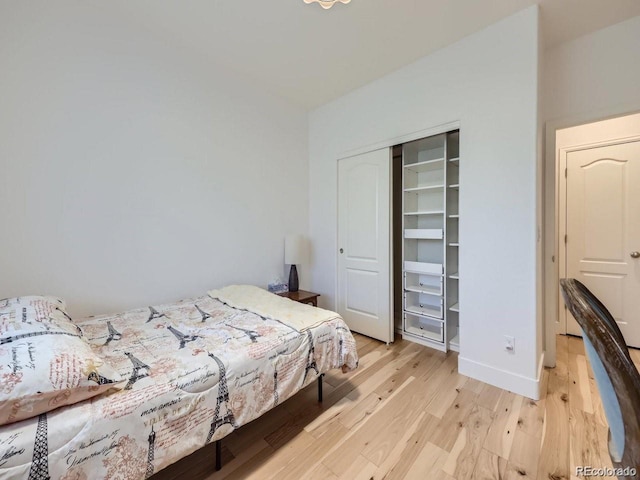 bedroom with light hardwood / wood-style floors and a closet