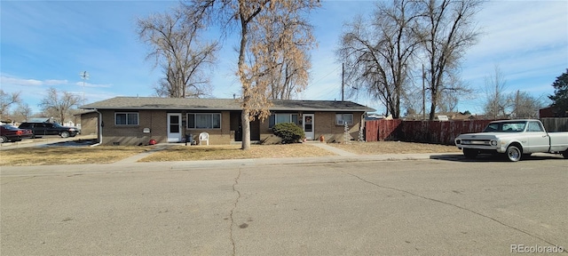 ranch-style house featuring crawl space, brick siding, and fence