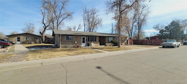 view of front of home featuring crawl space, a front yard, fence, and brick siding