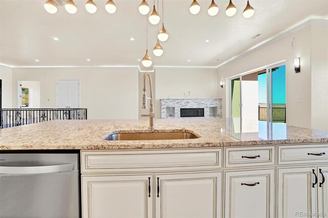 kitchen with pendant lighting, sink, ornamental molding, stainless steel dishwasher, and light stone countertops