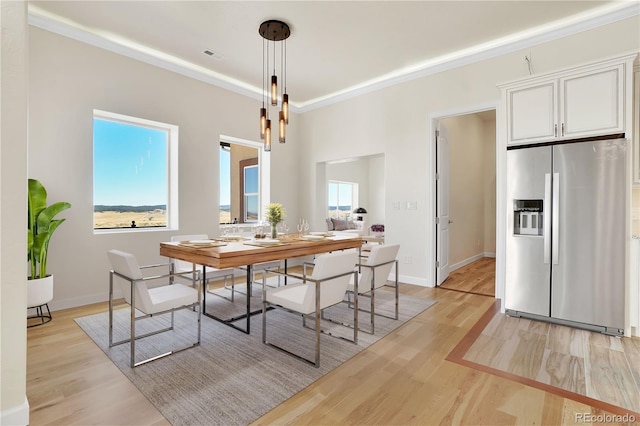 dining area featuring crown molding and light hardwood / wood-style floors