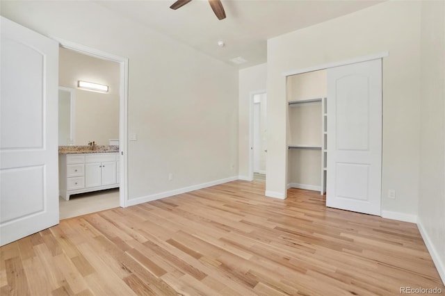 unfurnished bedroom with sink, light hardwood / wood-style flooring, ceiling fan, connected bathroom, and a closet