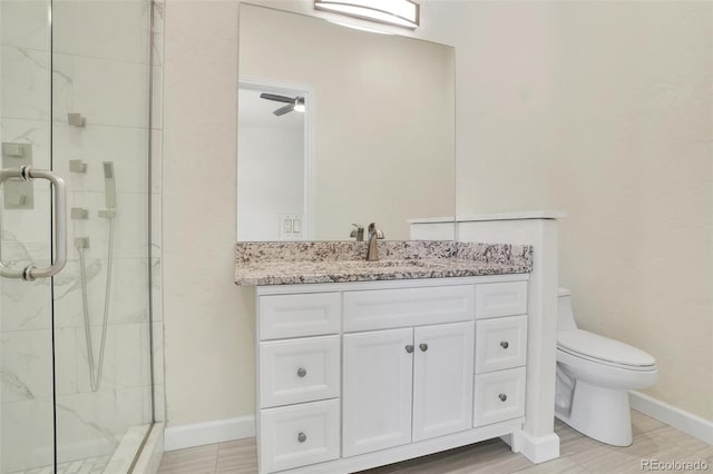 bathroom featuring vanity, toilet, and a shower with shower door