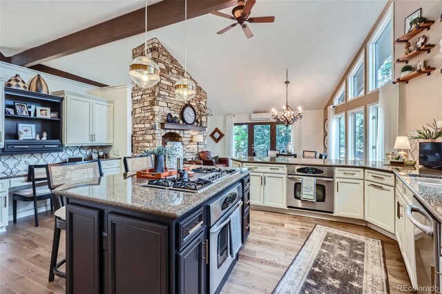 4856 Cheyenne Dr, Larkspur, CO 80118 - kitchen featuring stainless steel appliances, healthy amount of natural light, light stone counters, light wood finished floors, and high vaulted ceiling