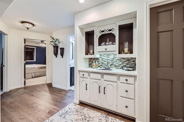 4856 Cheyenne Dr, Larkspur, CO 80118 - indoor wet bar featuring tasteful backsplash, wood finished floors, a ceiling fan, and baseboards