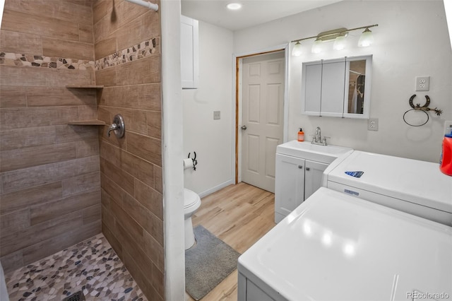780 Oak St, Hartsel, CO 80449 - bathroom featuring washer / clothes dryer, a tile shower, vanity, wood finished floors, and recessed lighting