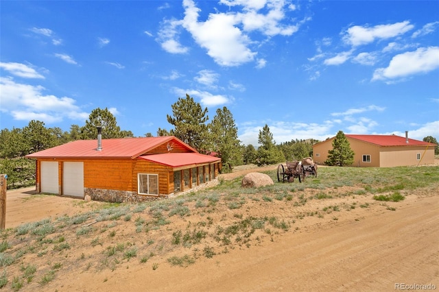 780 Oak St, Hartsel, CO 80449 - rear view of property with a metal roof, stone siding, and a garage