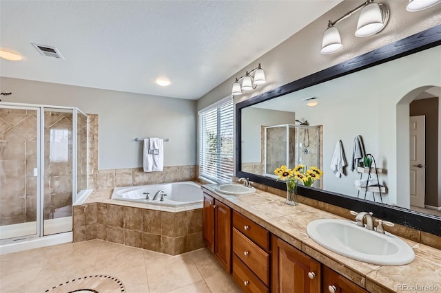 bathroom featuring a textured ceiling, tile patterned floors, vanity, and shower with separate bathtub